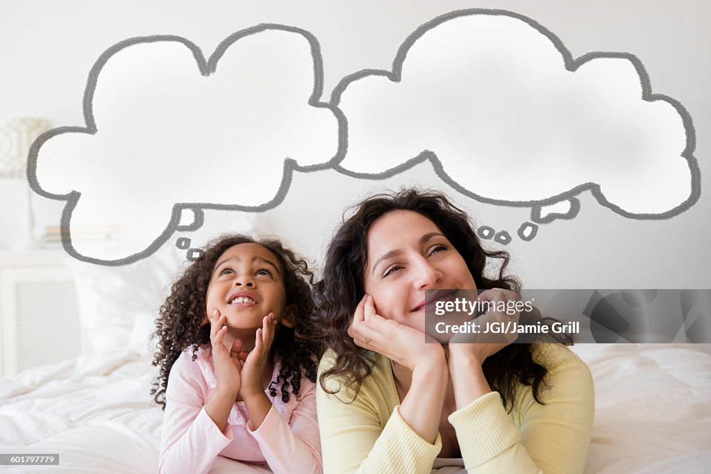 Mother and daughter thinking on bed