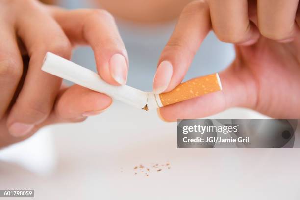 close up of hispanic woman breaking cigarette - 禁煙 ストックフォトと画像