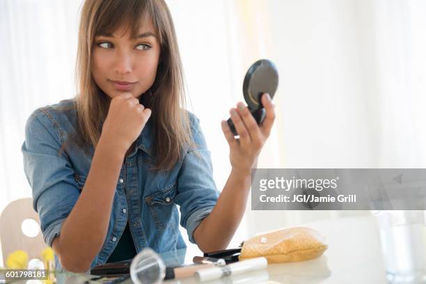 mixed race woman admiring herself in mirror - powder compact 個照片及圖片檔