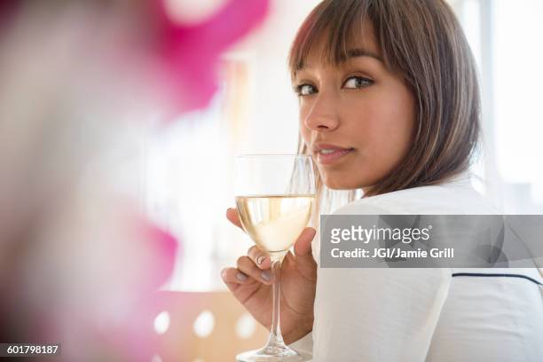 mixed race woman drinking white wine - brown hair drink wine stock-fotos und bilder