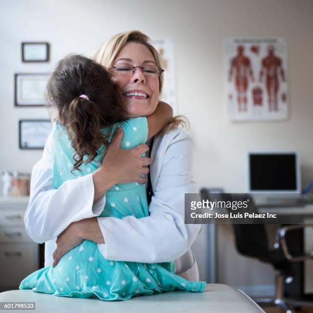 doctor and patient hugging in clinic - doctors embracing stock pictures, royalty-free photos & images