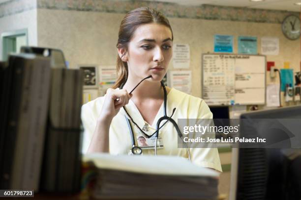 caucasian nurse using computer in hospital - nurse station stock pictures, royalty-free photos & images