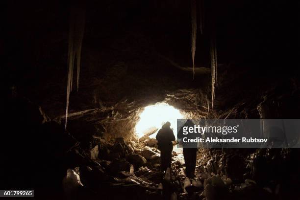 caucasian hikers exploring cave - spelunking stock-fotos und bilder