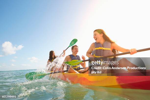 friends rowing canoe in ocean - kayaking stock pictures, royalty-free photos & images