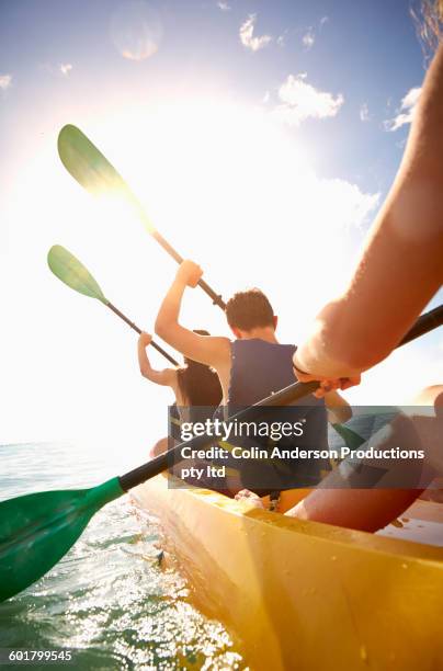 friends rowing canoe in ocean - kayak barco de remos fotografías e imágenes de stock