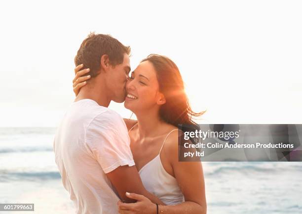 couple kissing on beach - blowing a kiss imagens e fotografias de stock