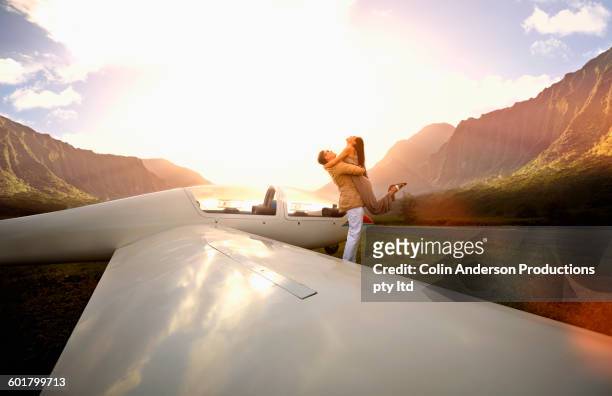 couple hugging at glider airplane on remote runway - native korean stock pictures, royalty-free photos & images