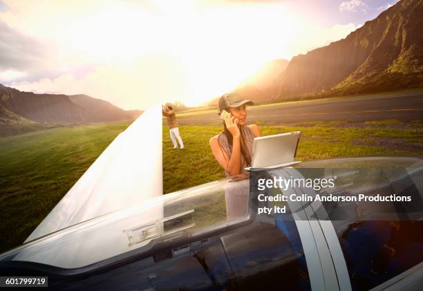 woman talking on cell phone at glider airplane - native korean stock pictures, royalty-free photos & images