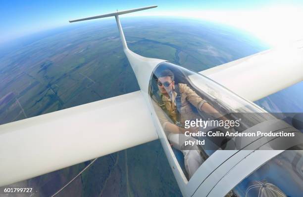 mixed race man flying glider airplane - aviation risk stock-fotos und bilder