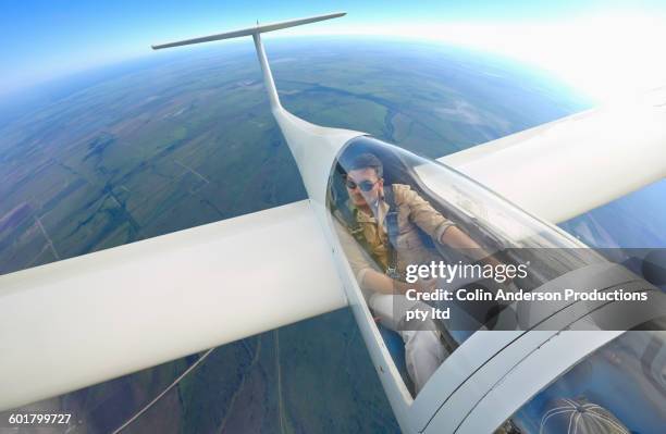 mixed race man flying glider airplane - zweefvliegtuig stockfoto's en -beelden