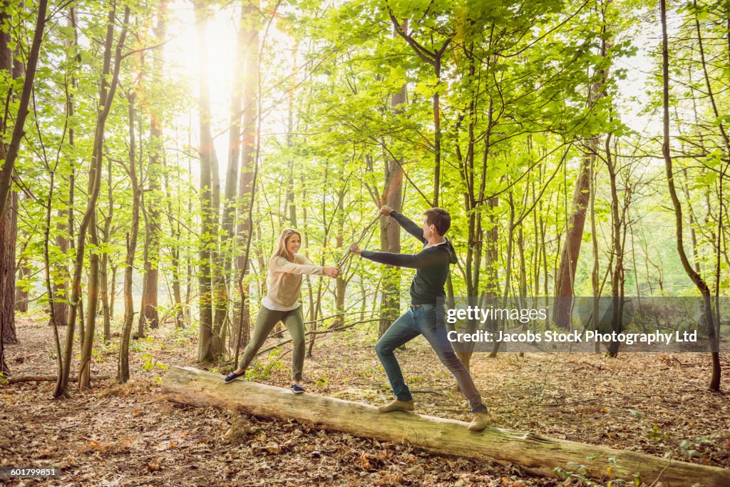 Caucasian couple playing in forest