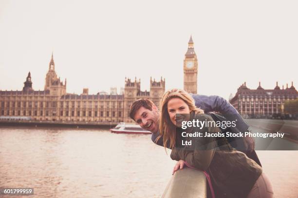 caucasian couple smiling at clock tower, london, middlesex, united kingdom - couple london stockfoto's en -beelden