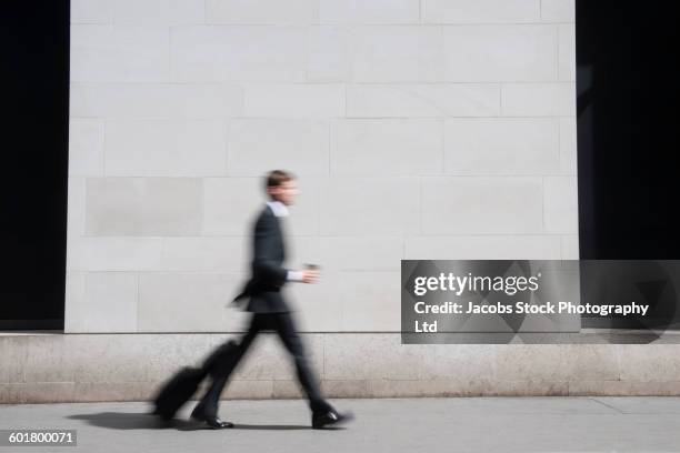 caucasian businessman walking on sidewalk - blurred motion people walking stock pictures, royalty-free photos & images