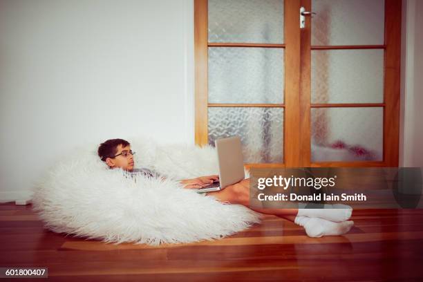 mixed race boy using laptop in beanbag - bean bags stock pictures, royalty-free photos & images