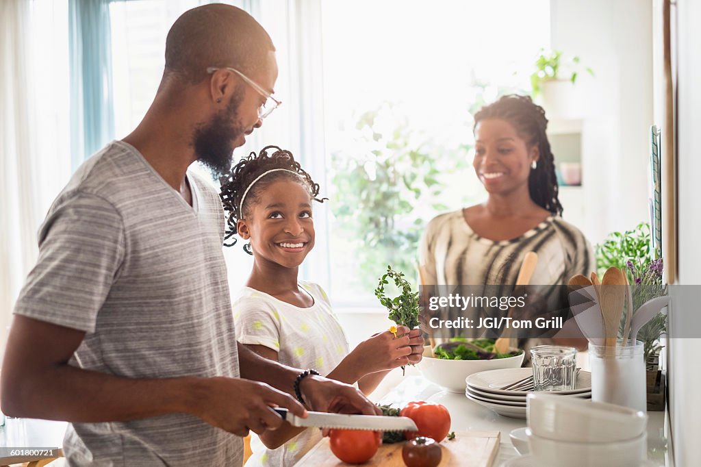 Black family cooking in kitchen