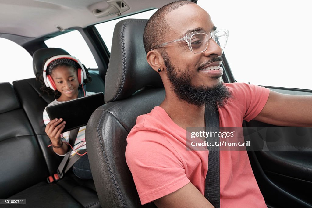 Black father and daughter driving in car