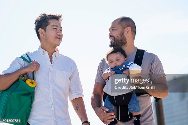 gay fathers doing errands with baby son - latin american and hispanic shopping bags stock pictures, royalty-free photos & images