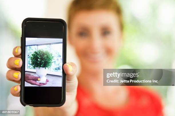 caucasian woman holding cell phone - tonen stockfoto's en -beelden