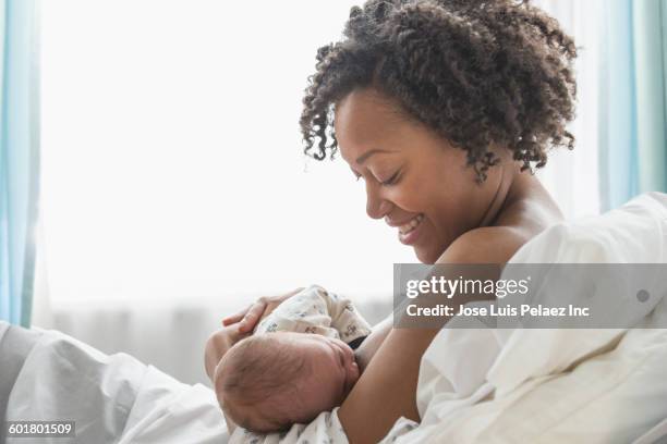 mixed race mother nursing newborn baby - hispanic man profile hopeful stock-fotos und bilder