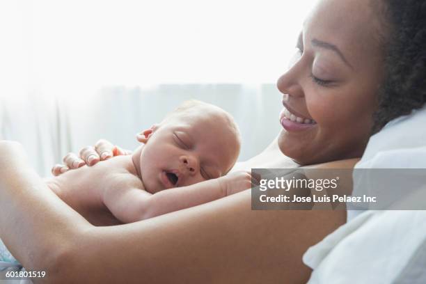 mixed race mother holding newborn baby in hospital - bröstkorg bildbanksfoton och bilder