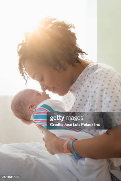 mixed race mother holding newborn baby - black mother and baby stock pictures, royalty-free photos & images