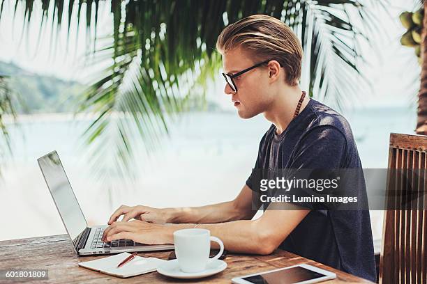 caucasian man using laptop in cafe - time off work stock pictures, royalty-free photos & images