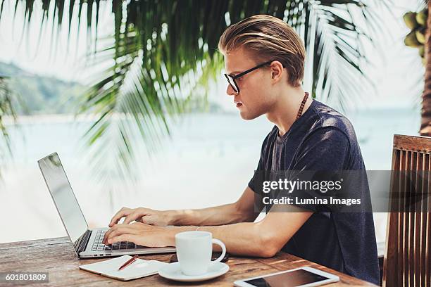 caucasian man using laptop in cafe - cafe at beach bildbanksfoton och bilder