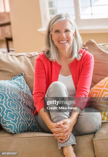 caucasian woman sitting on sofa - lehi stock-fotos und bilder