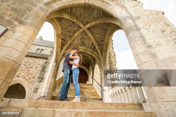 caucasian couple standing on castle steps - vitre stock-fotos und bilder