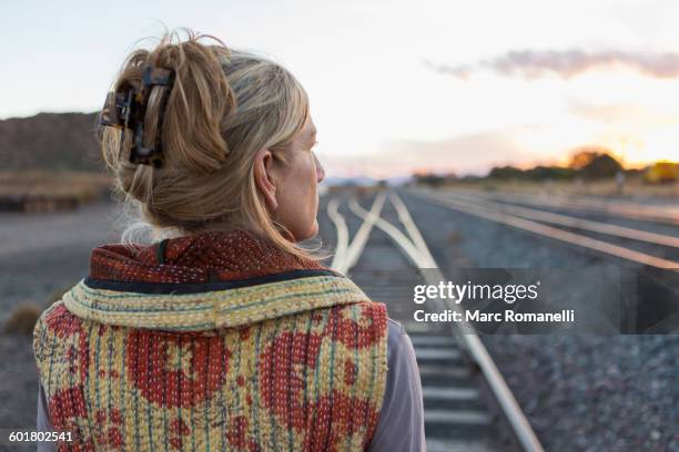 caucasian woman standing on train tracks - railway tracks sunset stock pictures, royalty-free photos & images