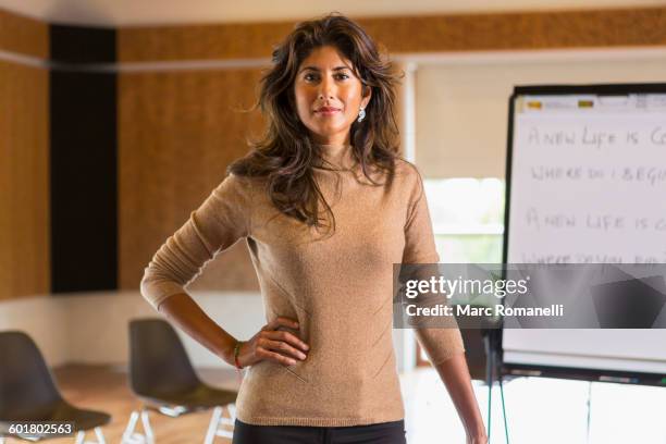 hispanic businesswoman standing in meeting room - ecuadorian ethnicity stock pictures, royalty-free photos & images