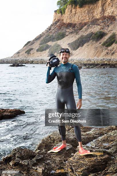 hispanic diver wearing wetsuit on beach - wetsuit stock pictures, royalty-free photos & images