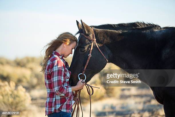 caucasian woman hugging horse in field - muzzle human stock pictures, royalty-free photos & images