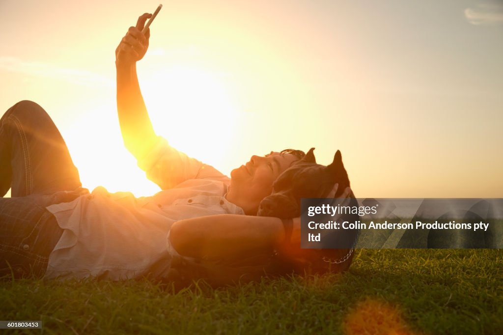 Korean man taking selfie with dog in field