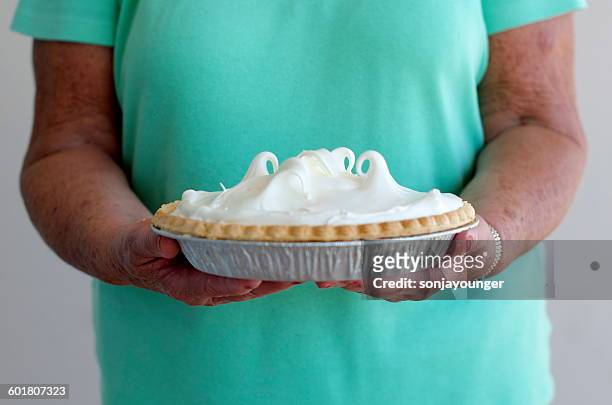 senior woman holding key lime pie - key lime pie stock pictures, royalty-free photos & images