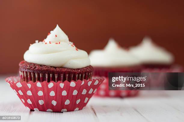 three red velvet cupcakes on table - red velvet material stock-fotos und bilder