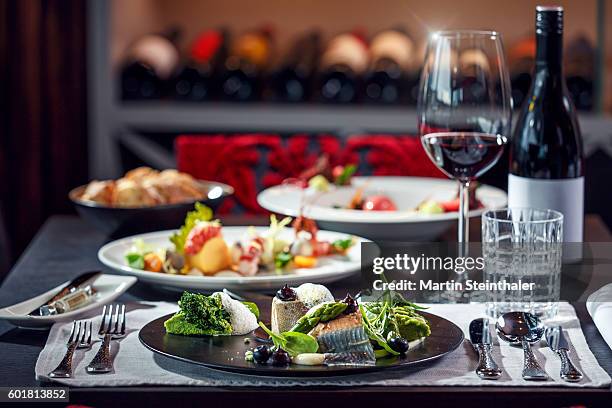 gourmet dinner: delicate fish carefully arranged with green vegetables - luxury table setting stock pictures, royalty-free photos & images