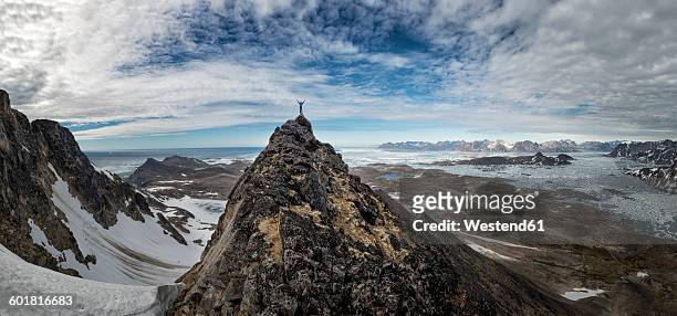 greenland, schweizerland, kulusuk, mountaineer on mountaintop - aiming higher stock pictures, royalty-free photos & images