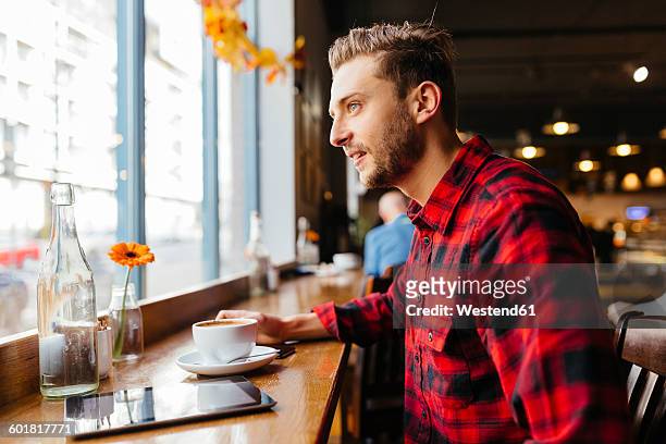 man in a coffee shop looking out of window - daily life in ireland stock pictures, royalty-free photos & images