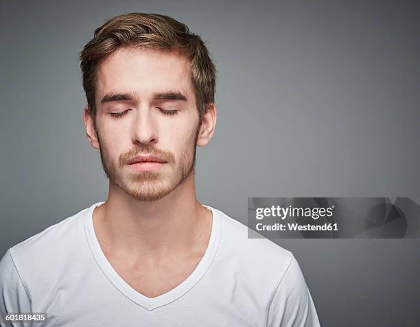 portrait of young man with closed eyes - occhi chiusi foto e immagini stock