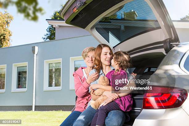 grandmother, mother and daughter in car boot with teddy bear in front of house - mama bear - fotografias e filmes do acervo