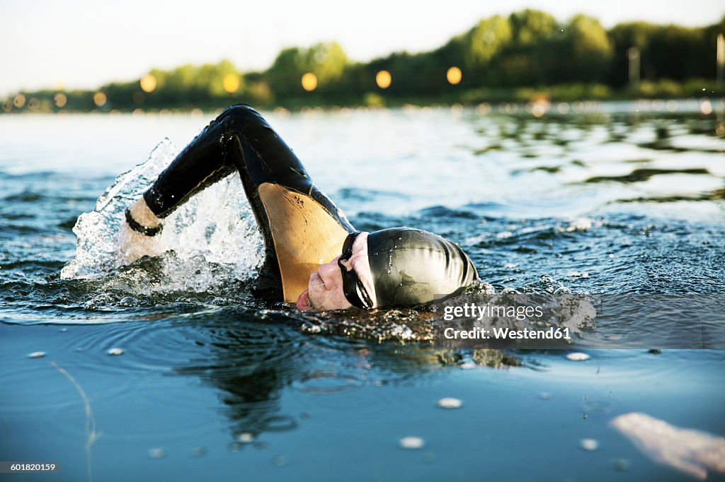 Triathlete swimming in lake