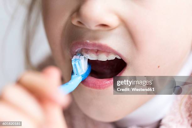 little girl brushing her milk teeth, close-up - mouth hygiene brush stock pictures, royalty-free photos & images