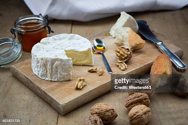 camembert, bread, walnuts and honey on wood - camembert stock-fotos und bilder