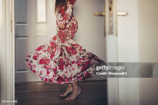 young woman in floral dress moving on the floor - floral pattern dress stock pictures, royalty-free photos & images