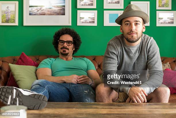 two friends relaxing on the couch at home - two houses side by side stock pictures, royalty-free photos & images