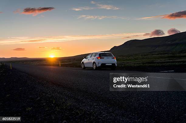 iceland, car on road under midnight sun - car on road photos et images de collection