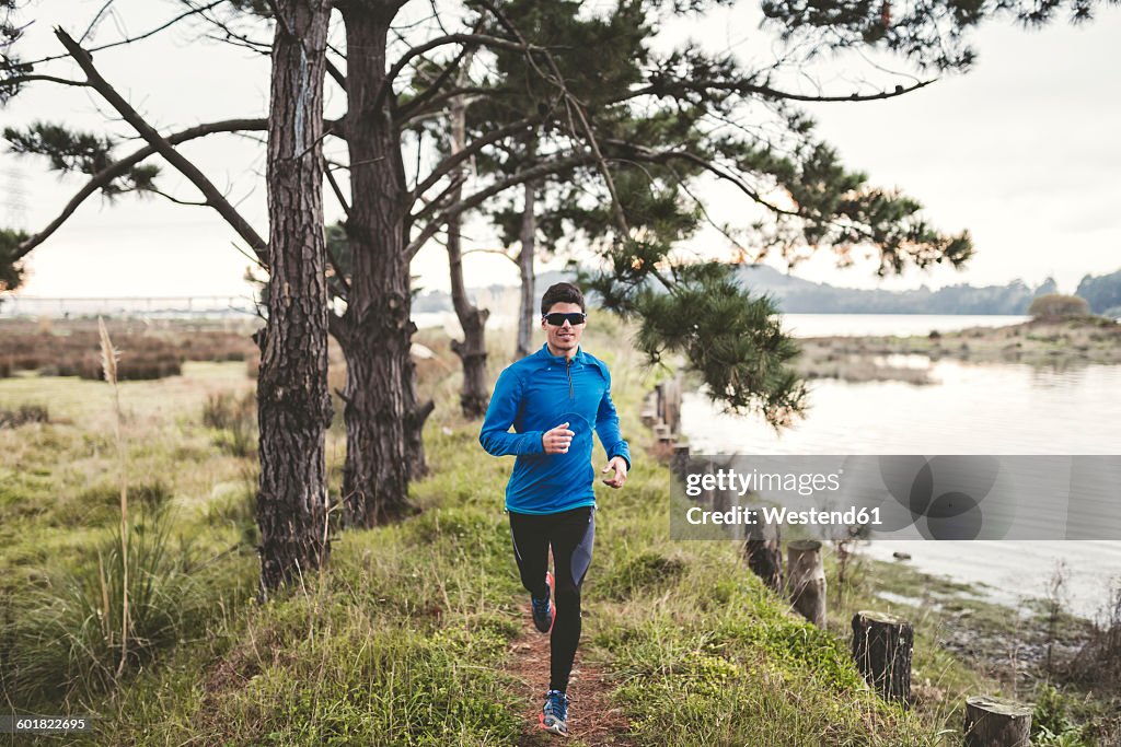 Spain, Naron, jogger running on a path in the shore of the sea