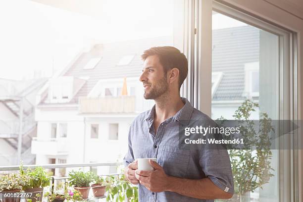 smiling man looking out of window - coffee cup top view stock pictures, royalty-free photos & images