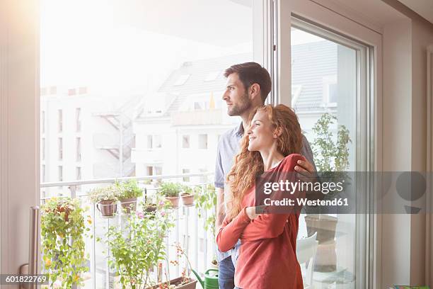 couple looking out of window - couple balcony stock-fotos und bilder